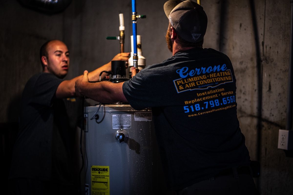 Plumbers installing water heater in basement – Cerrone Plumbing & HVAC serving Glens Falls NY