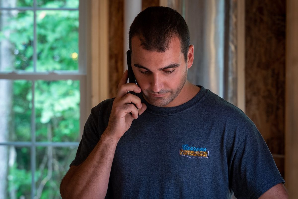 Cerrone Plumbing & HVAC technician speaking on phone at job site in Saratoga Springs NY