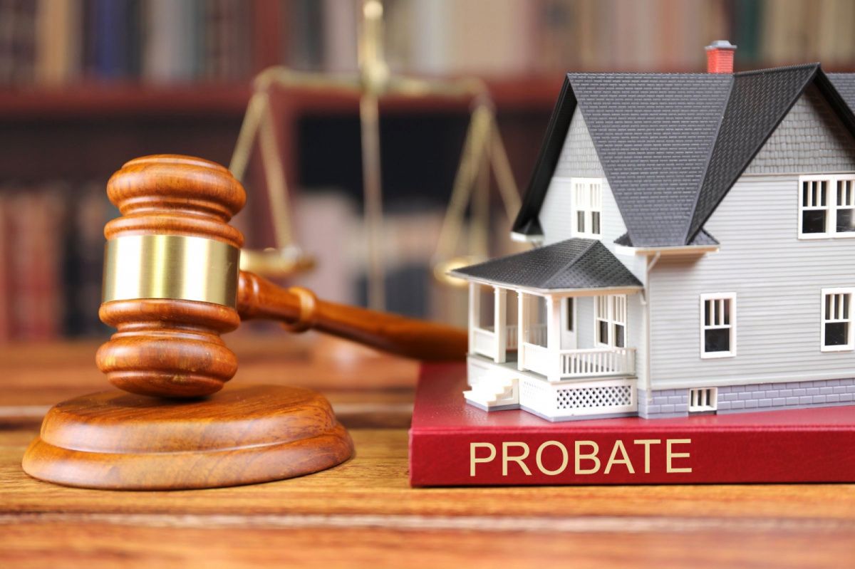 book that says probate with a model house on top to the right of a gavel