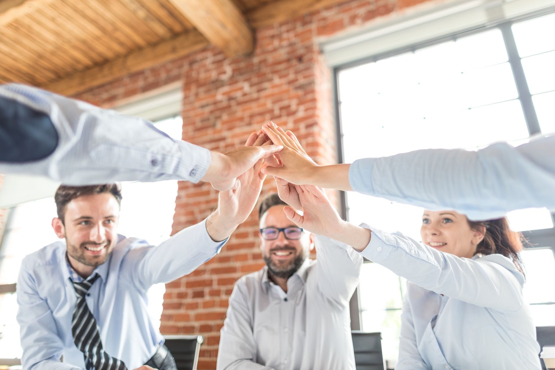 Business people happy showing team work and giving five in office. Teamwork concepts.