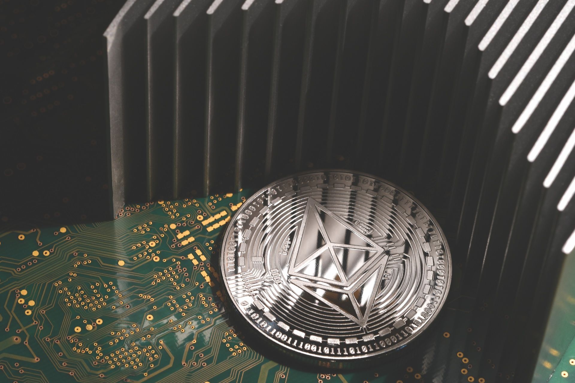 close-up of Ethereum ETH cryptocurrency over printed electronic circuit board with aluminum heatsink.