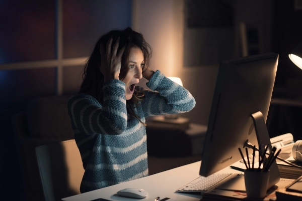 woman looking shocked at computer