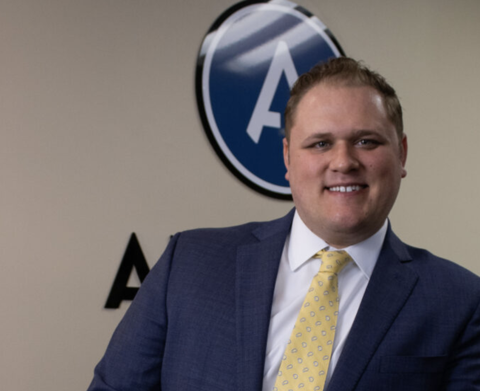 man in front of a big a on the wall