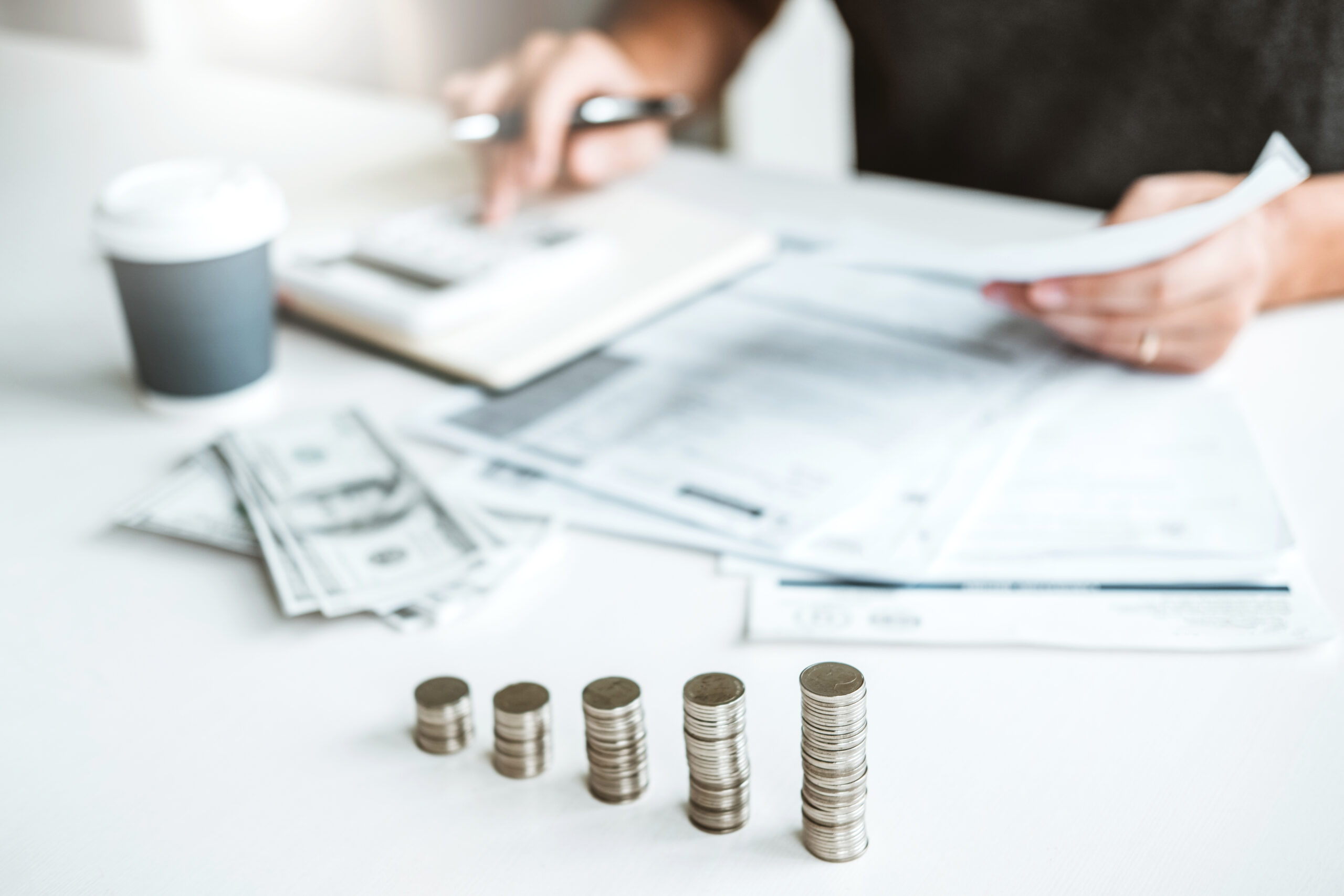 Man using calculator Accounting Calculating Cost Economic bills with money stack step growing growth saving money in home , finance concept