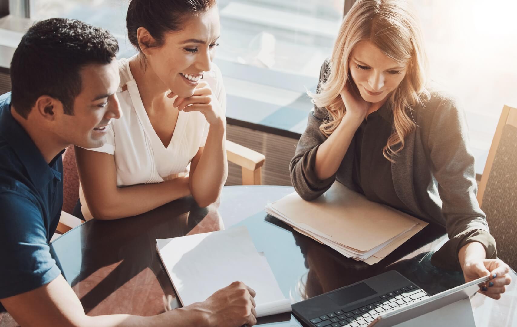 Group, people and laptop in office for business or online ideas, planning with client for blockchain investment. Female broker, couple and diversity in workplace with computer for research on crypto