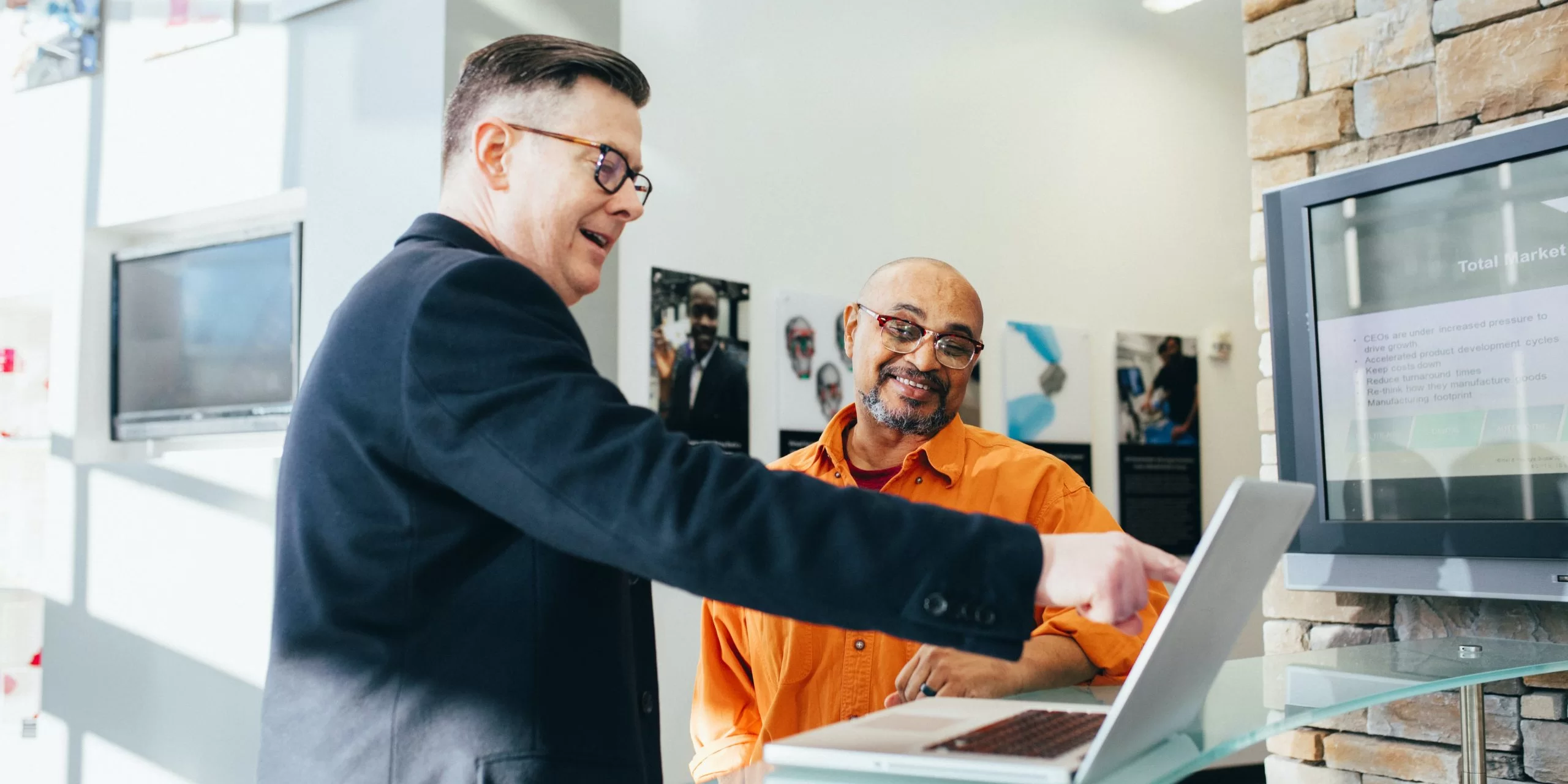 two men pointing at computer screen