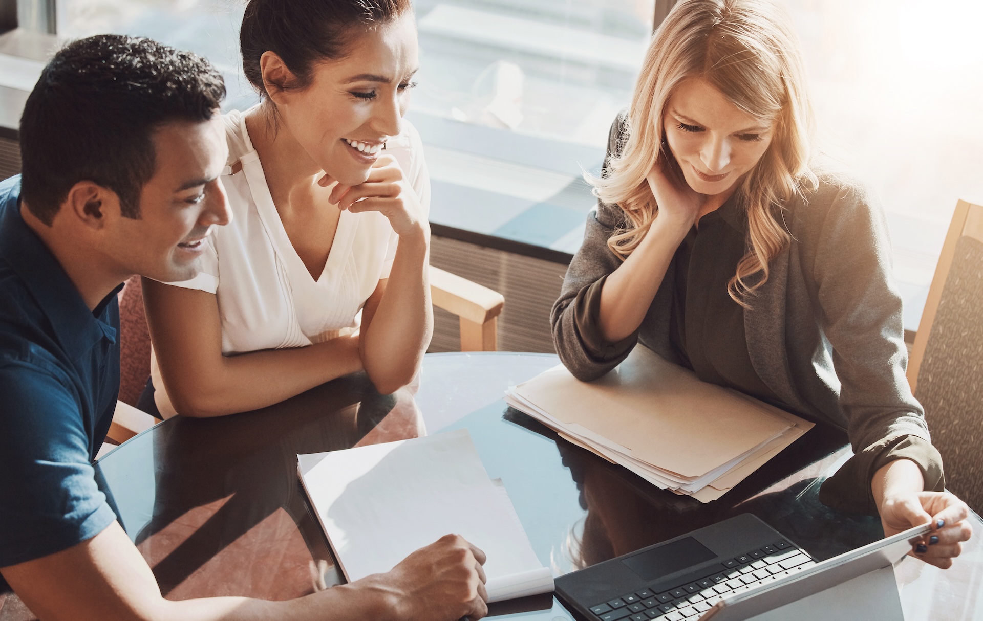 three people looking at a laptop