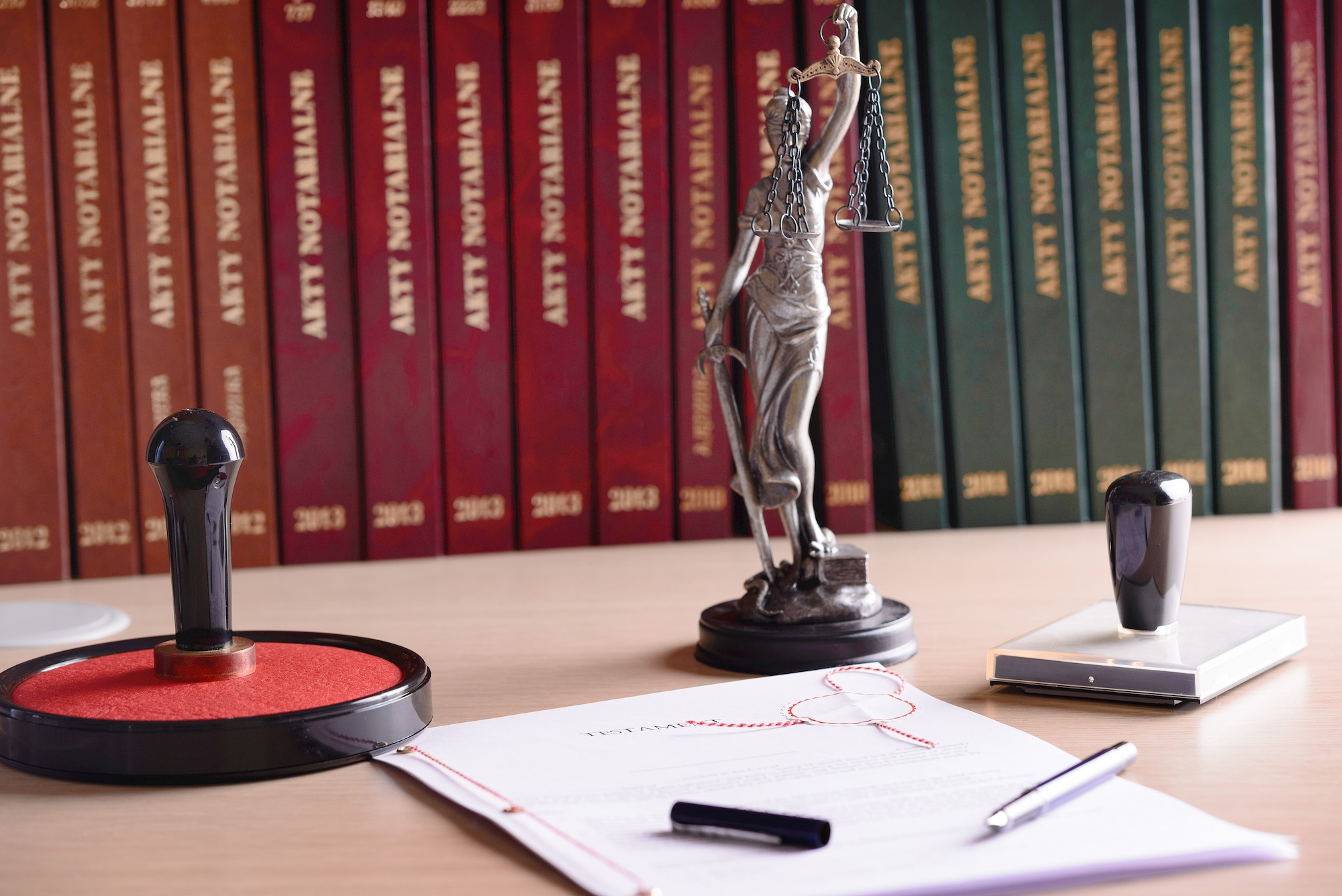 Notary public accessories. Themis with scales of justice and notarial acts in the background.