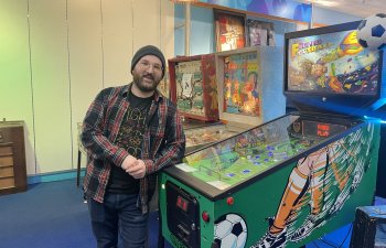 man next to old arcade machines