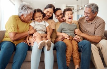 Happy, big family and quality time bonding of children, parents and grandparents together on a sofa. Laughing kids having fun with mom, dad and grandparent on a home living room couch with happiness