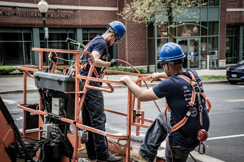 two men getting on a forklift