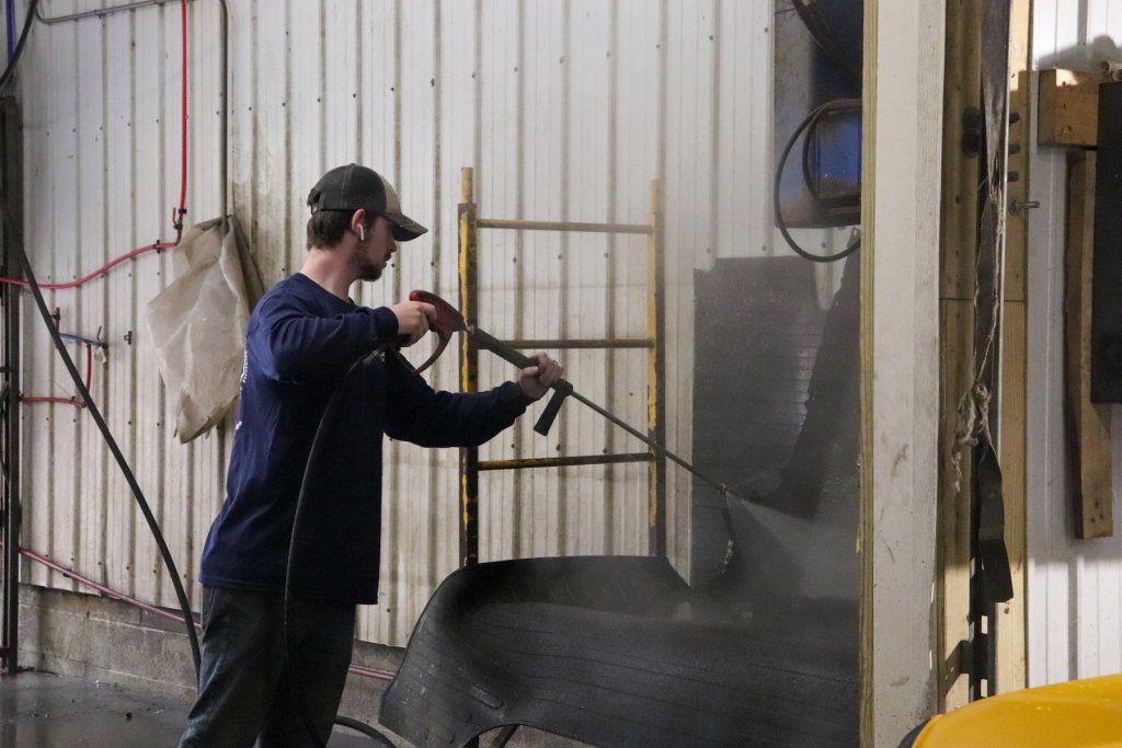 man spraying tires with water