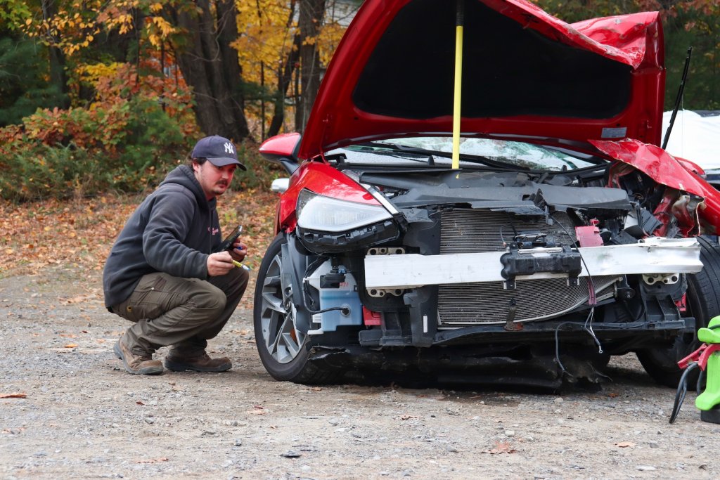 person next to destroyed car