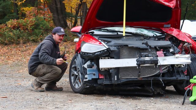 person next to destroyed car